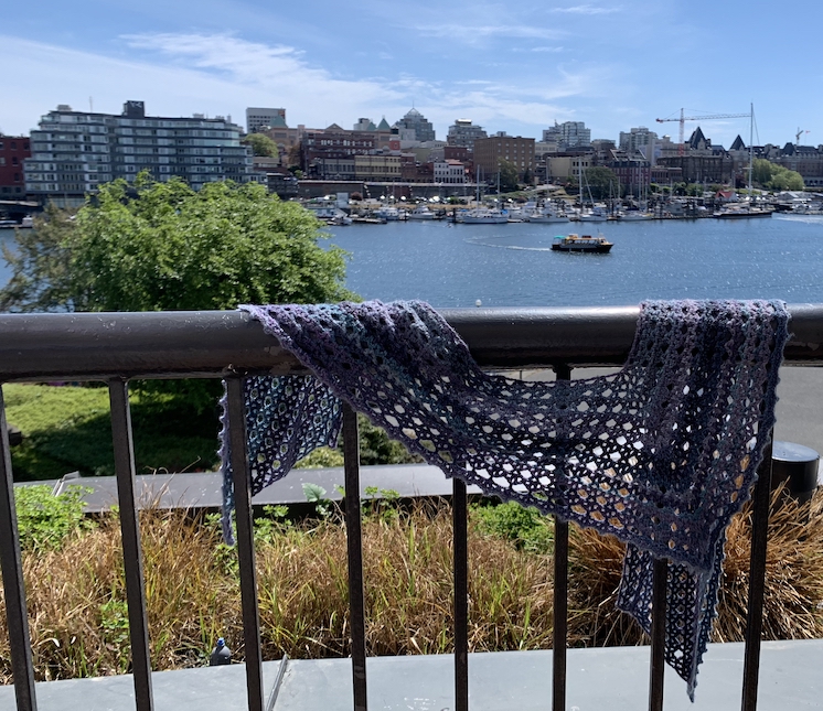 Scarf on rail with harbor in the background.